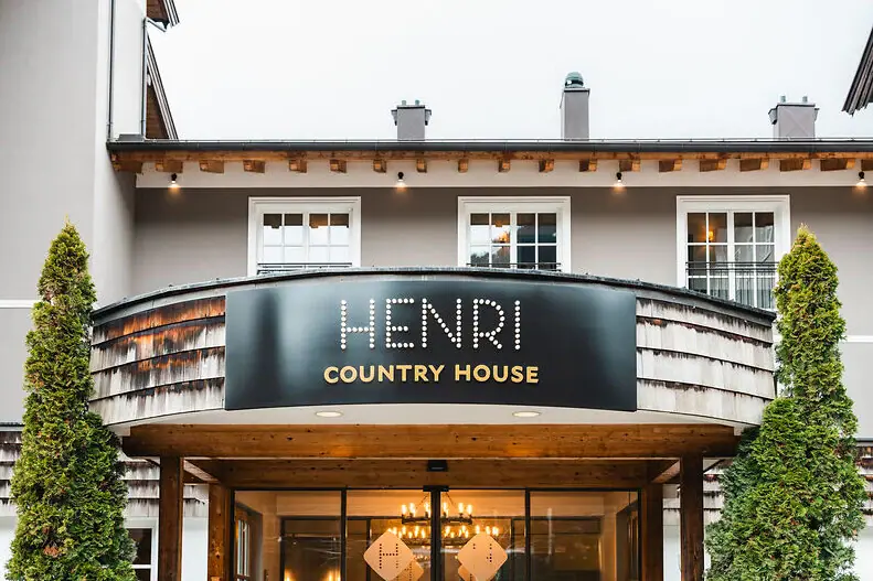 Haupteingang HENRI Kitzbühel Ein Schild an einem Gebäude.