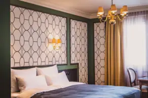 Zimmer Ein Bett mit einem Kronleuchter und Vorhängen.