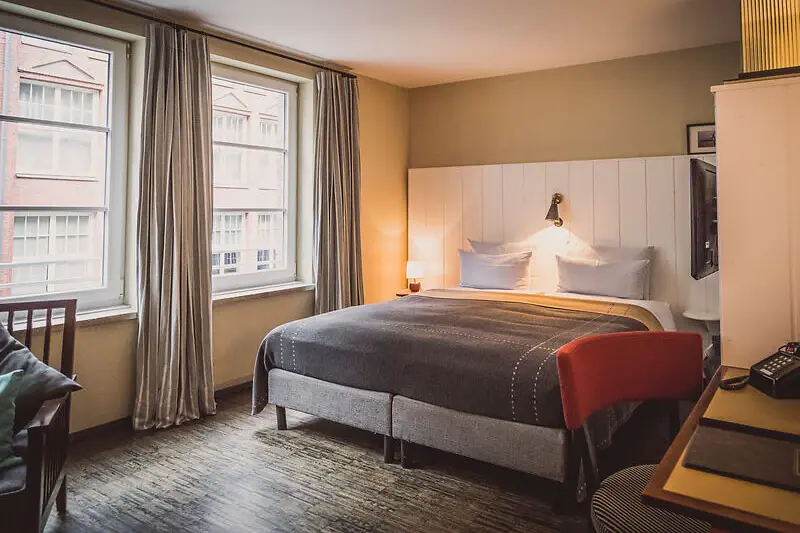 Zimmer im HENRI Ein Schlafzimmer mit einem Bett und einem Schreibtisch.