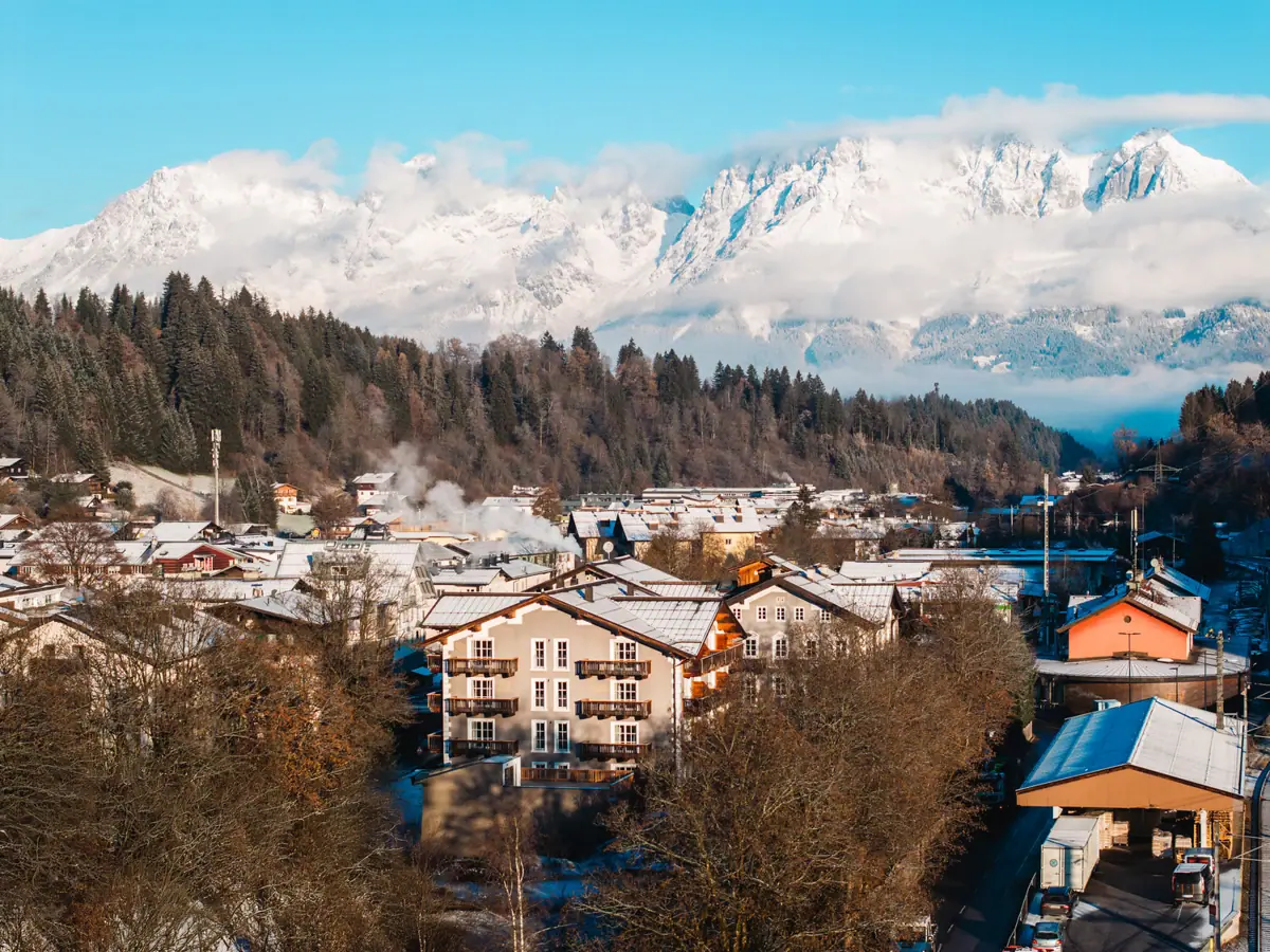 HENRI Kituzbühel Ein Bergdorf mit schneebedeckten Bergen im Hintergrund.