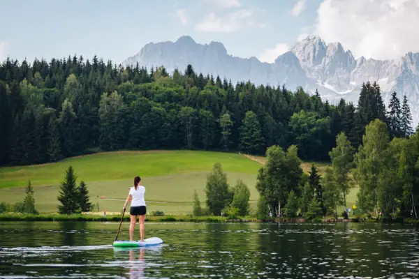 Eine Frau auf einem Paddleboard auf einem See.