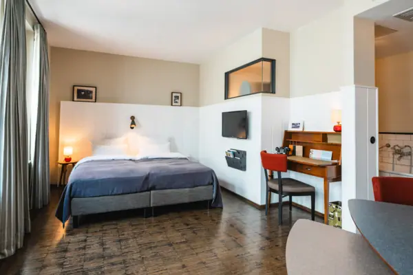 Zimmer im HENRI Hamburg Ein Zimmer mit einem Bett und einem Schreibtisch.
