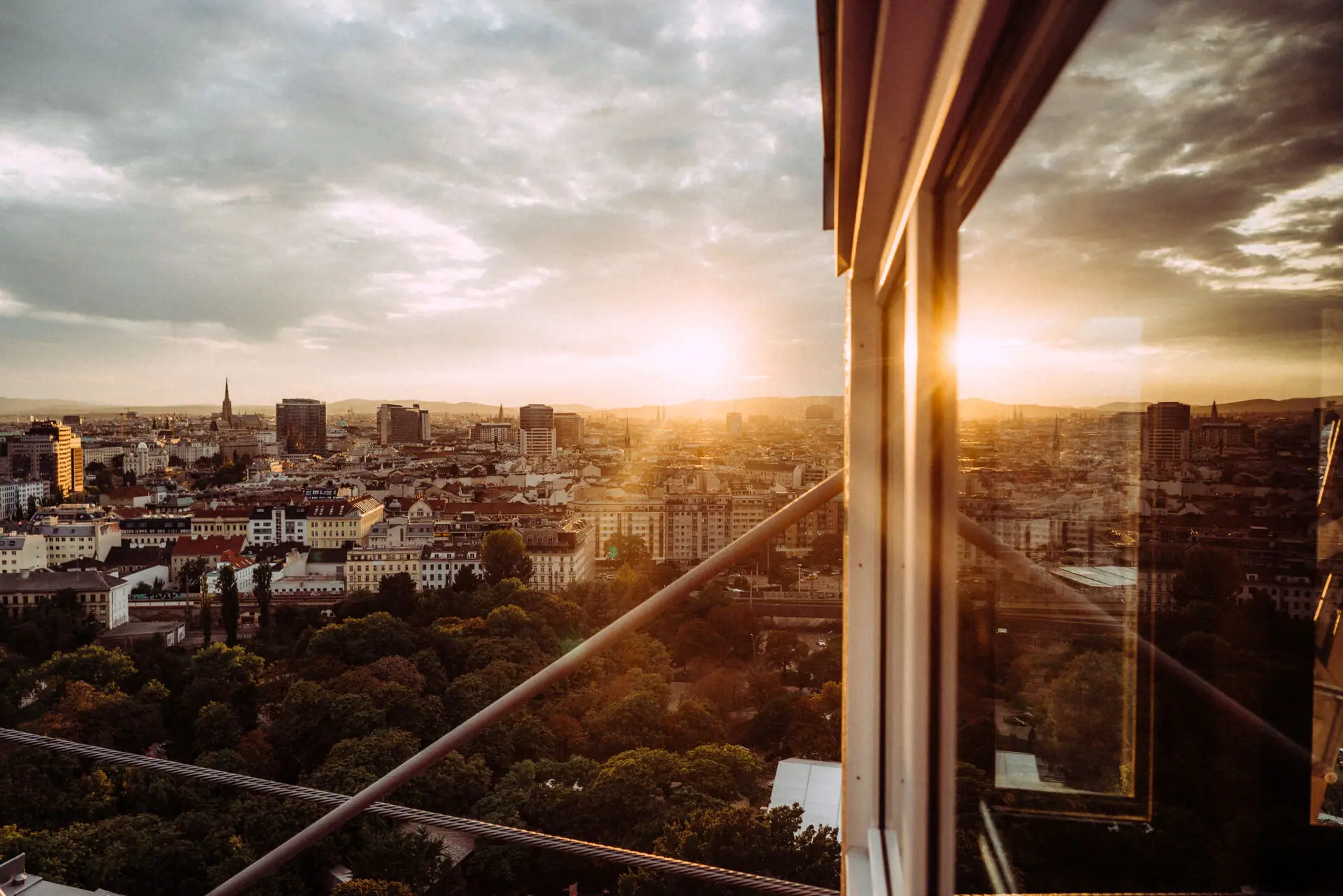 Blick über Wien Blick auf eine Stadt durch ein Fenster mit Wolken und Gebäuden im Hintergrund.