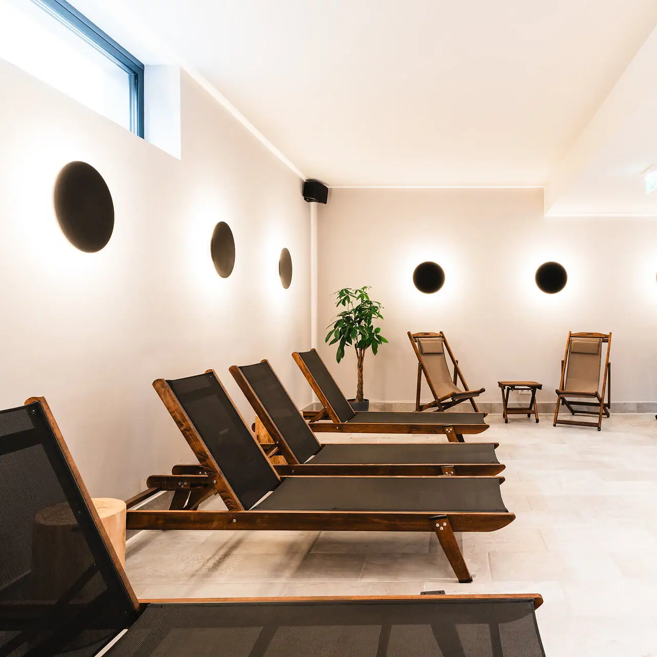 Spa-Liegen Ein Raum mit Stühlen und einer Pflanze.