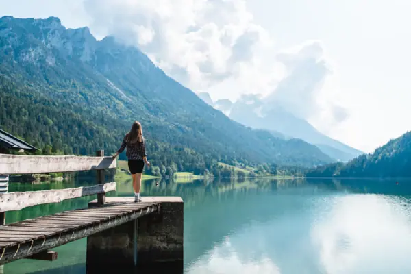 Hintersteinersee bei Kitzbühel Eine Frau steht auf einem Steg und blickt auf einen See.
