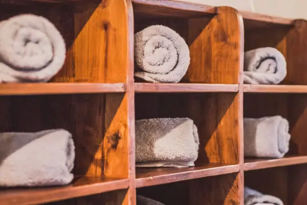 Holzregal mit gerollten weißen Handtüchern Holzregal mit gerollten weißen Handtüchern