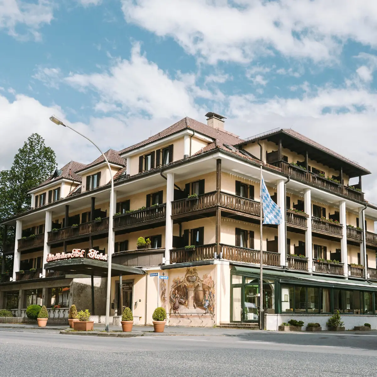 HENRI Garmisch-Partenkirchen Ein Gebäude mit vielen Balkonen und einer Fahne.