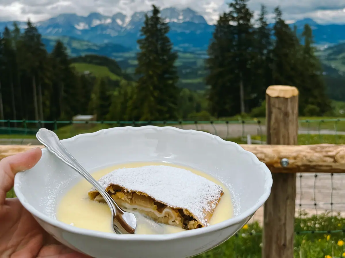 Eine Hand hält eine Schüssel mit Essen und einem Löffel.