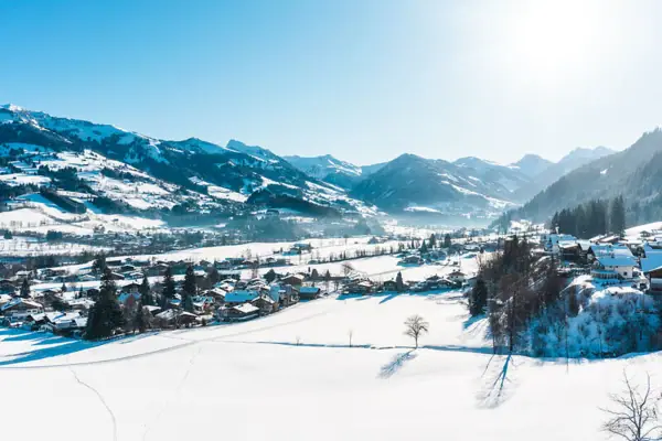 Kitzbühel im Winter Verschneite Landschaft mit Häusern und Bergen im Hintergrund.