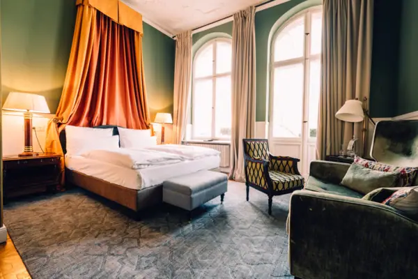Zimmer im HENRI Hotel Berlin Ein Zimmer mit einem Bett und Stühlen.