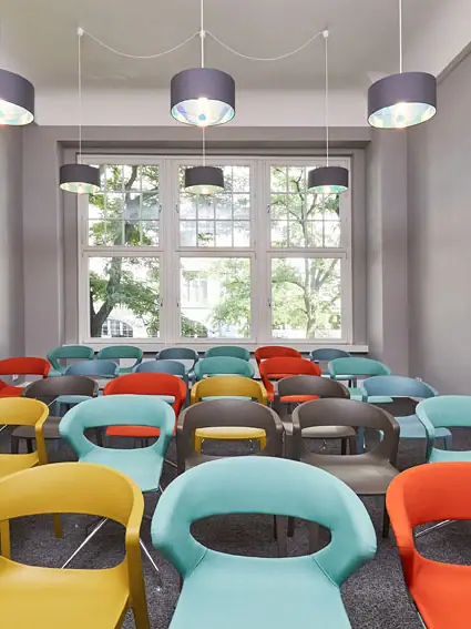 Coworking Space in Hamburg Ein Raum mit vielen bunten Stühlen.