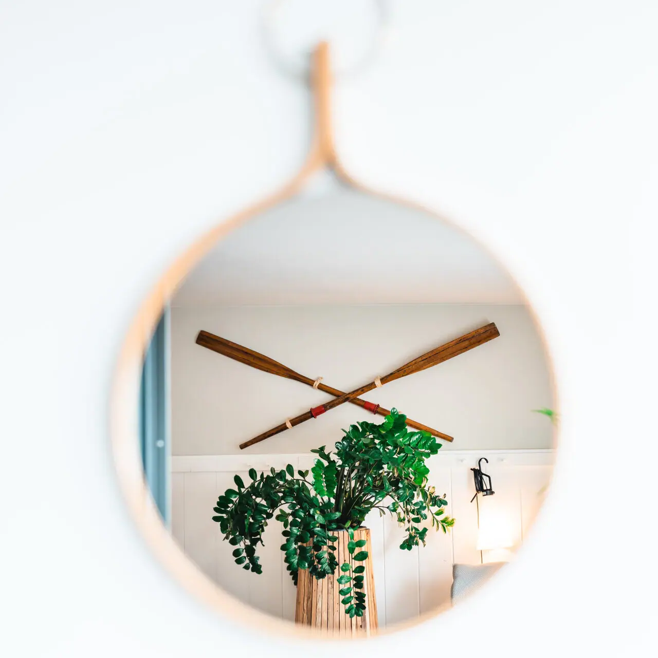 Spiegel an einer Wand Spiegel mit einer Pflanze im Topf.