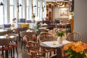 Offene Wohnlounge im HENRI Hotel Hamburg Tische und Stühle in Loungebereich