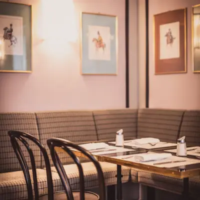 Reiterstüberl im HENRI Wien Ein Tisch mit einem Set aus Servietten und Stühlen in einem Restaurant.