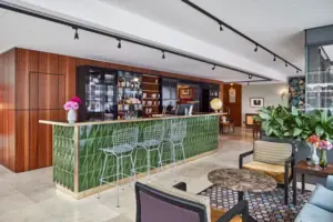 HENRI Düsseldorf Bar mit grünen Fliesen und Stühlen.