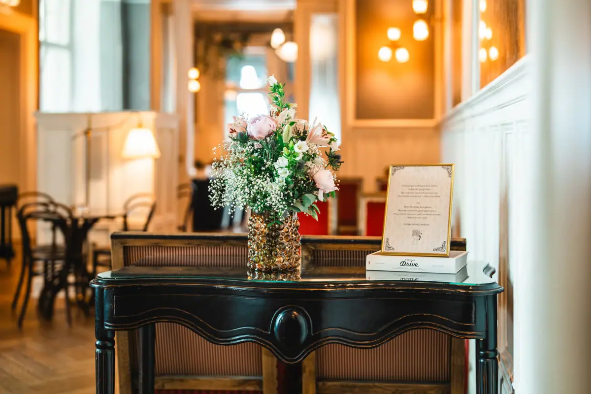 HENRI Berlin Eine Vase mit Blumen auf einem Tisch.