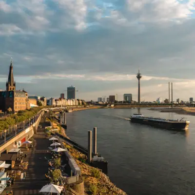 Düsseldorf Rheinufer Ein Fluss mit einem Boot darauf.