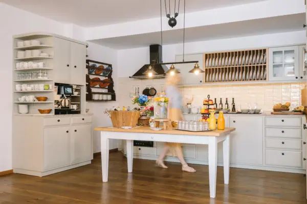 HENRI Kitzbühel Hausküche Eine Frau geht in einer Küche.