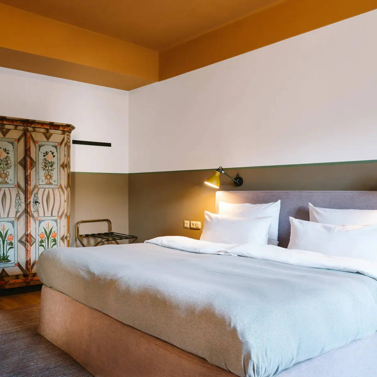 Hotelzimmer HENRI Garmisch-Partenkirchen Ein Zimmer mit einem Bett und einem Schrank.