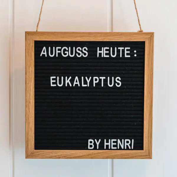Schild mit Aufgussankündigung Ein rechteckiges Schild mit Text an einer Wand.