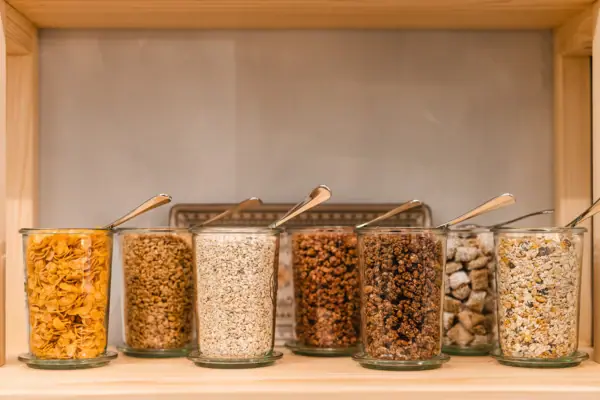 Cerealien Eine Gruppe von Glasbehältern mit Löffeln.