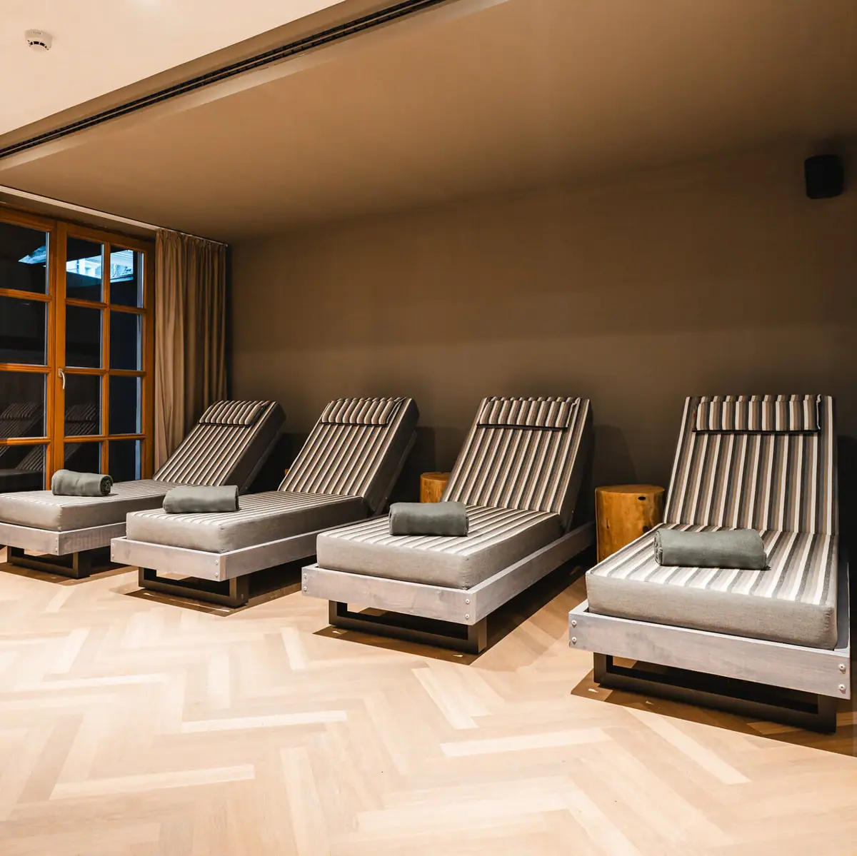 Ruheoase im HENRI Hotel Kitzbühel Eine Gruppe von Liegestühlen in einem Raum.