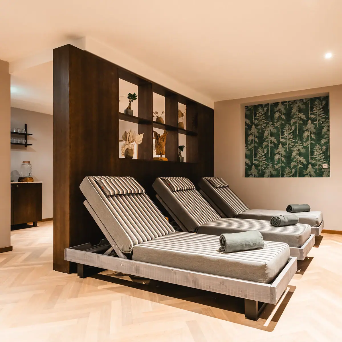 Entspannungsraum im HENRI Hotel Kitzbühel Ein Zimmer mit Sesseln und einer Wand im Innenbereich.