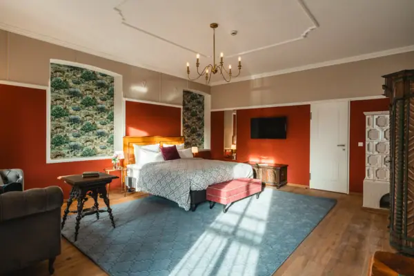 HENRI Kitzbühel Hotelzimmer Schlafzimmer mit Bett und Teppich.
