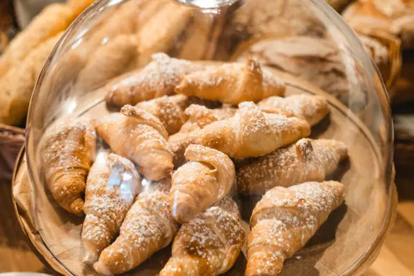 Croissants Ein Teller mit Croissants, bestäubt mit Puderzucker.