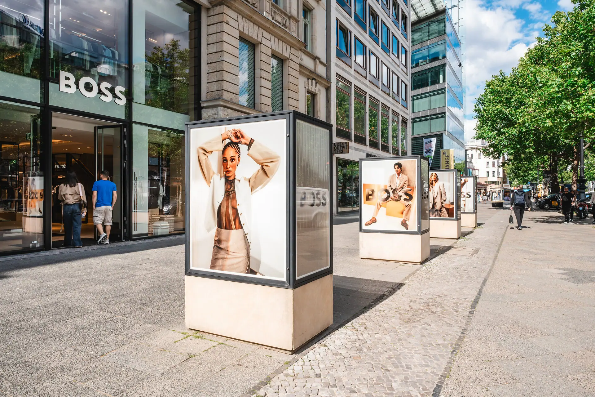 HENRI Berlin Kudamm Eine Gruppe von Schildern auf einem Bürgersteig.