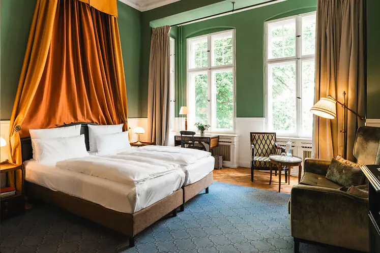 Zimmer im HENRI Hotel Berlin Ein Zimmer mit zwei Betten und einem Sofa.