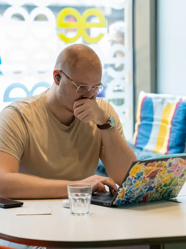 Beehive Düsseldorf Ein Mann sitzt an einem Tisch und stützt sein Gesicht mit der Hand.