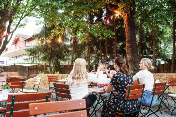 HENRI Kitzbühel Eine Gruppe von Menschen sitzt an Tischen im Freien.