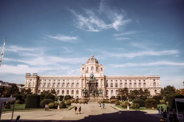 Museumsgebäude in Wien Großes Gebäude mit einer Statue davor, umgeben von Bäumen und Himmel im Hintergrund.