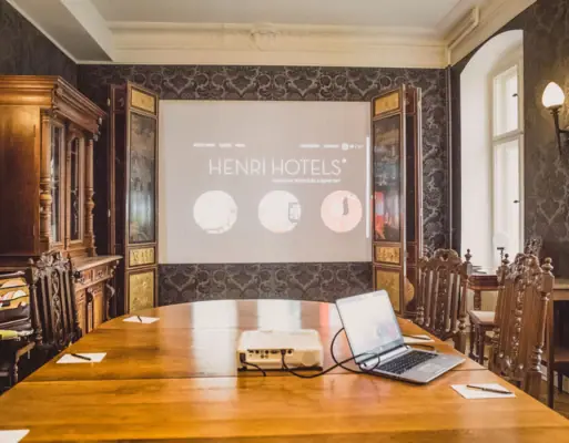 HENRI Berlin Tagungsraum Ein Tagungsraum mit einem Tisch und einem Projektor.