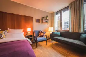 L-Studio HENRI Düsseldorf Das L-Studio Hotelzimmer im HENRI Hotel Düsseldorf mit einem Bett und einem Sofa.