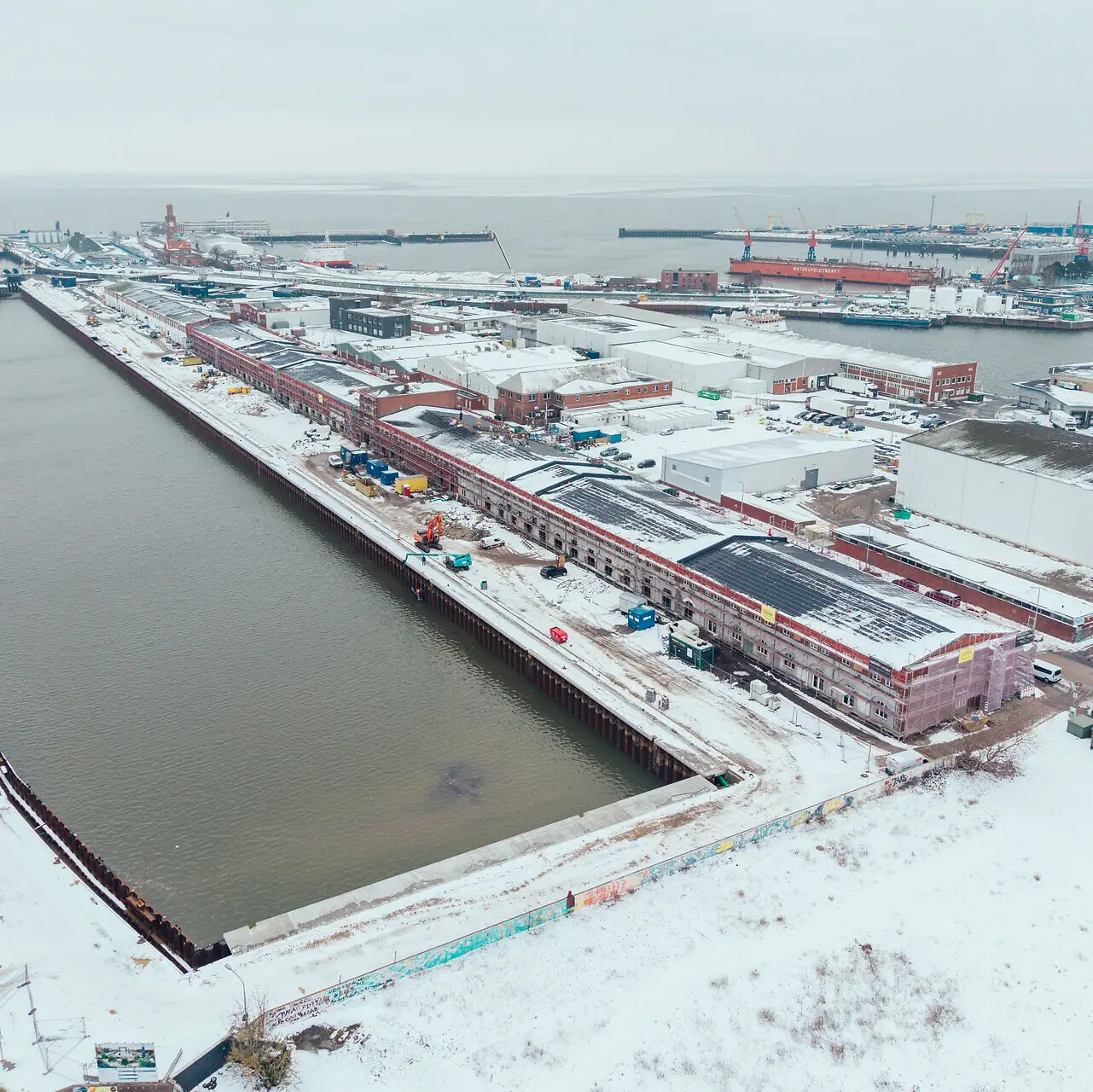 HENRI Hotel Cuxhaven Verschneite Stadt neben einem Gewässer aus der Vogelperspektive im Winter.
