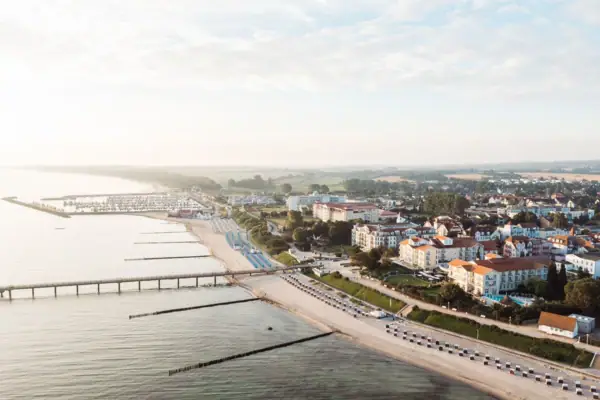 A-ROSA Ostseehotel Kühlungsborn Stadt neben einem Gewässer aus der Vogelperspektive mit Himmel und Wolken.