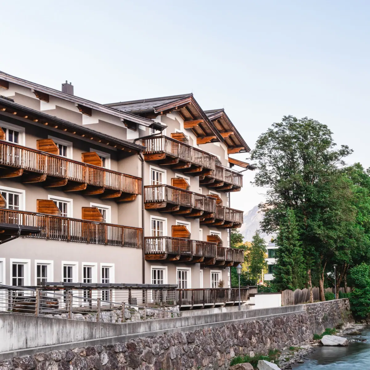 HENRI Hotel Kitzbühel an der Tiroler Ache Ein Gebäude neben einem Fluss.