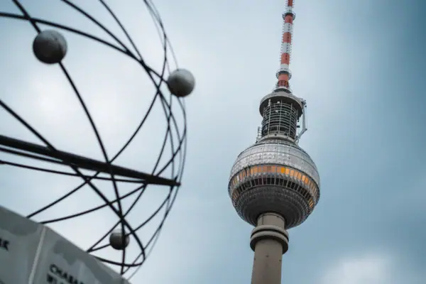 Berlin Alexanderplatz Der Berliner Alexanderplatz mit hohem runden Turm vor blauem Himmel mit Wolken.