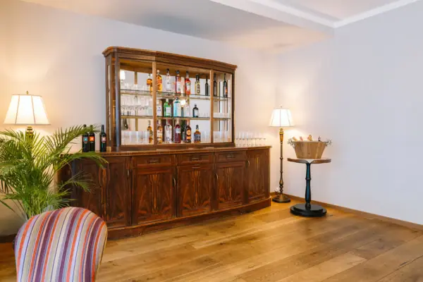 Ache Galerie 2 im HENRI Hotel Kitzbühel Ein Zimmer mit einem Schrank, einem Tisch und Stühlen.