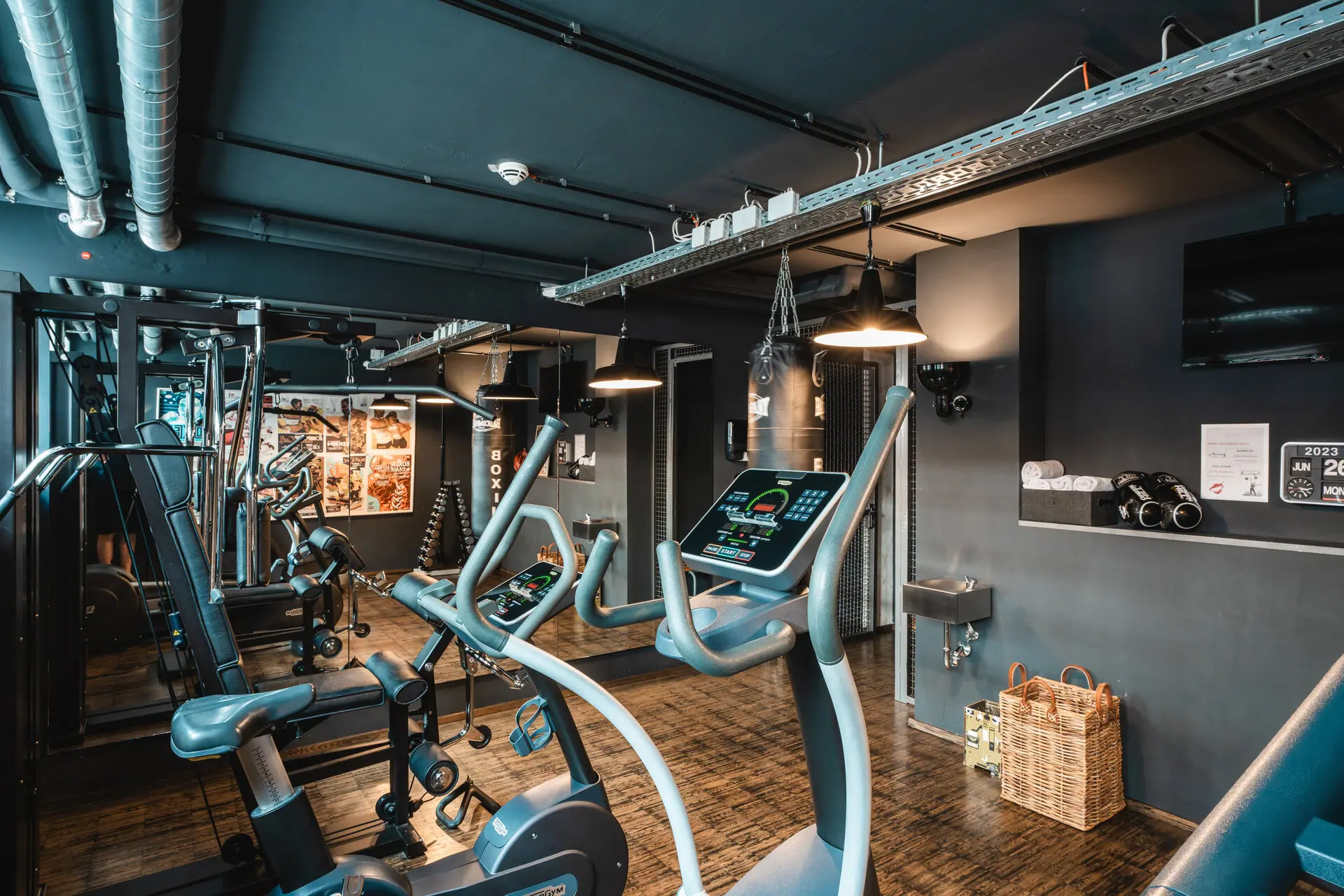 Fitnessraum im HENRI Hotel Hamburg Ein Raum mit Fitnessgeräten und Holzboden.