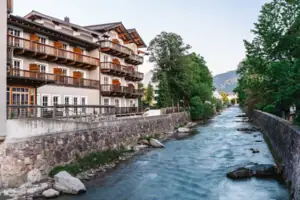 HENRI Kitzbühel Ein Fluss mit einem Gebäude und Bäumen.