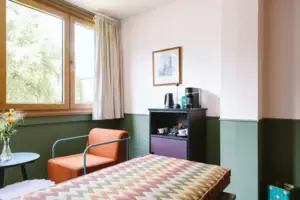 Hotelzimmer im HENRI Hotel Garmisch-Partenkirchen Eine Zimmerbar mit Kaffee- und Teestation im Chambre im HENRI Hotel Garmisch-Partenkirchen.