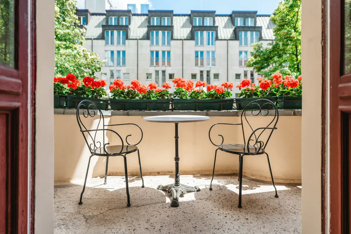 HENRI Berlin Zimmer Ballkon Ein Tisch und Stühle auf einer Terrasse.