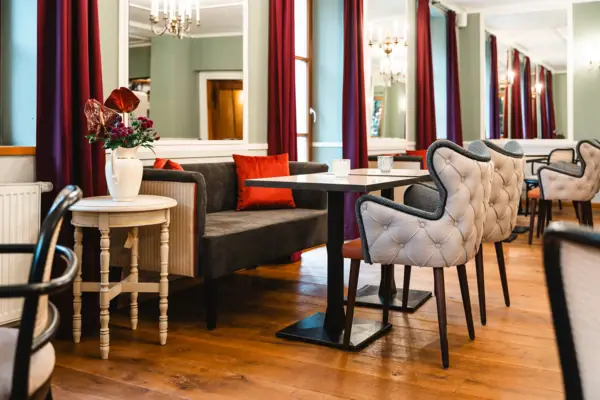 Spiegelsaal im HENRI Hotel Kitzbühel Ein Zimmer mit einem Sofa, Tischen und Stühlen.