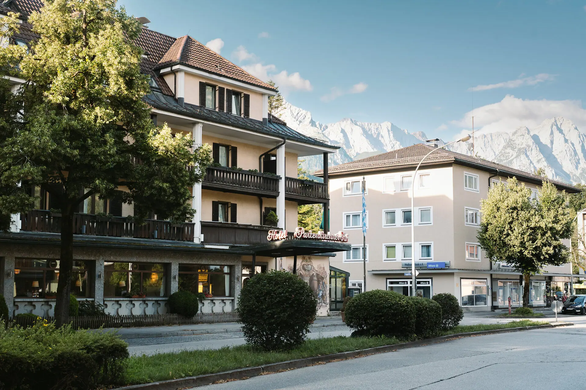 Außenansicht HENRI Hotel Garmisch-Partenkirchen Außenansicht HENRI Hotel Garmisch-Partenkirchen mit Bäumen und einer Straße.