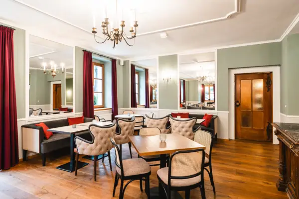 Spiegelsaal im HENRI Hotel Kitzbühel Ein Raum mit Tischen und Stühlen.