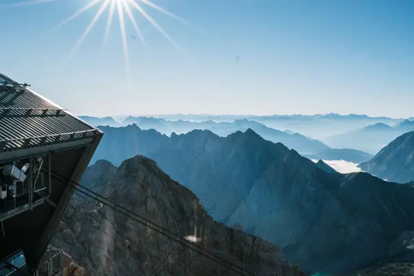Ausblick Zugspitze Der Ausblick von der Zugspitze mit Bergkette, Seilbahn und strahlender Sonne.