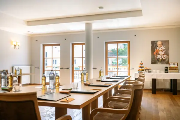 Raum Ache Galerie 1 im HENRI Hotel Kitzbühel Ein Raum mit einem Tisch und Stühlen.